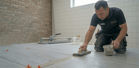 Fliesenleger beim Verfugen der Fliesen